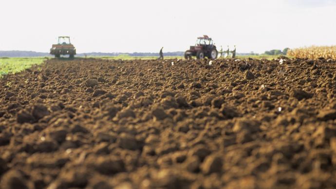 Photo d'un labour avec des tracteurs en arrière-plan