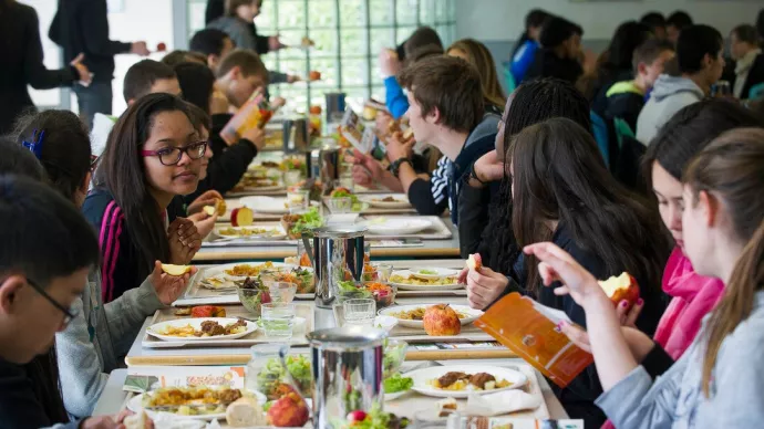 Des collégiens déjeunent à la cantine scolaire.