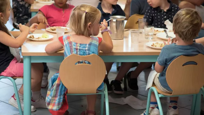 Un groupe d'enfants en train de manger à la cantine scolaire.