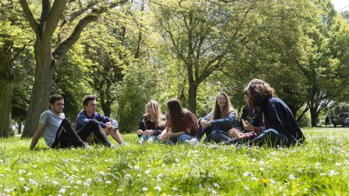 Elèves assis en cercle dans l'herbe