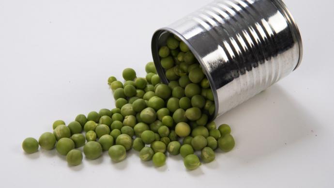 Une boîte de conserve de petit pois ouverte.