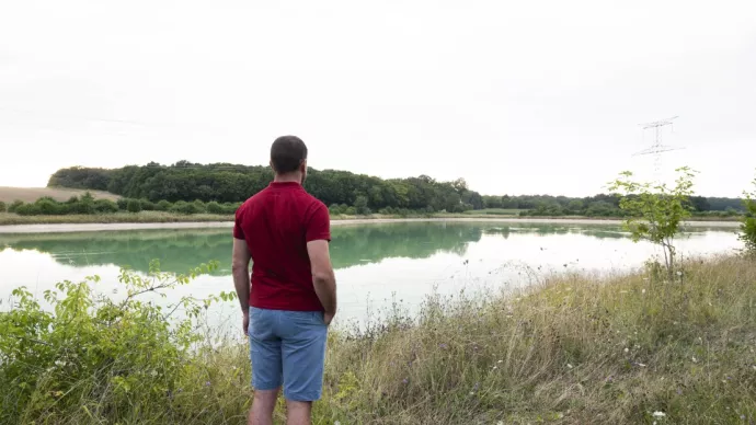 Agriculteur devant une réserve d'eau