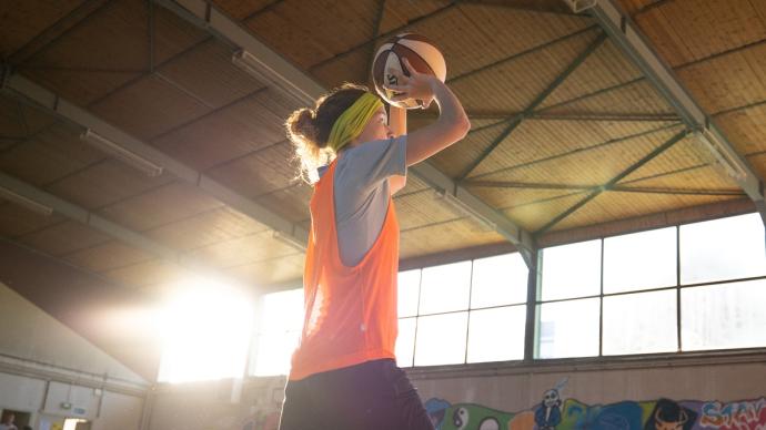 Une élève en train de jouer au basket-ball