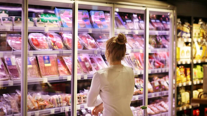 Femme devant rayon de charcuterie