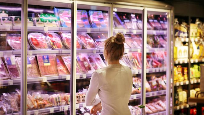 Femme devant rayon de charcuterie