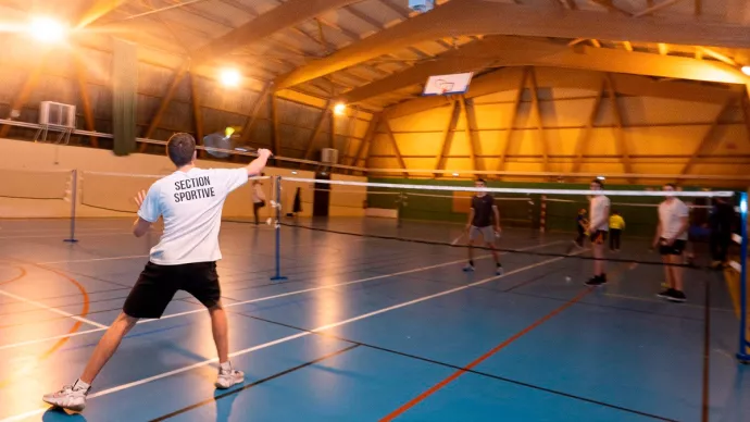 Groupe de jeunes pratiquant le badminton dans un gymnase