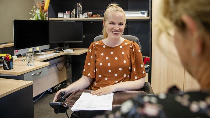 femme en fauteuil roulant dans un bureau